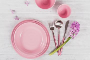 Pink rustic table setting with purple hyacinth flower and linen napkin on white wooden table