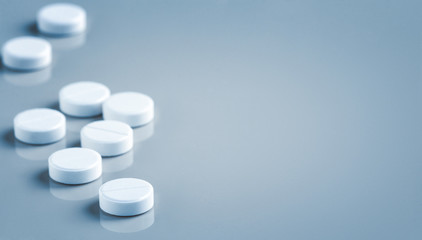 white pills on a blue background with copy space