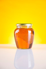 Sweet honey in the comb, glass jar on wooden background