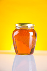 Sweet honey in the comb, glass jar on wooden background