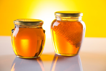 Sweet honey in the comb, glass jar on wooden background