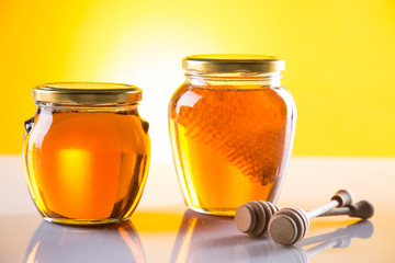 Sweet honey in the comb, glass jar on wooden background