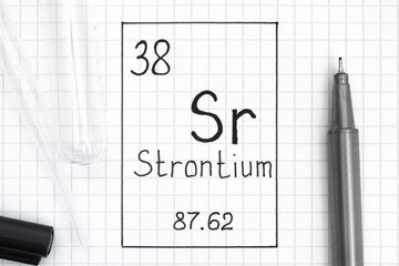 Handwriting chemical element Strontium Sr with black pen, test tube and pipette.