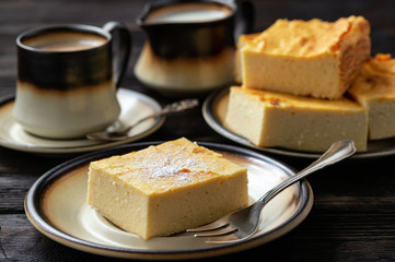 Homemade sliced cheesecake and the cup of coffee. 
