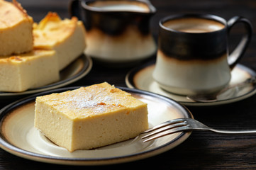 Homemade sliced cheesecake and the cup of coffee. 
