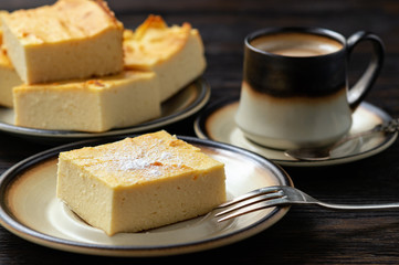 Homemade sliced cheesecake and the cup of coffee. 