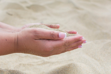 Female hands with sand. Summer vacation on the beach. Close up.