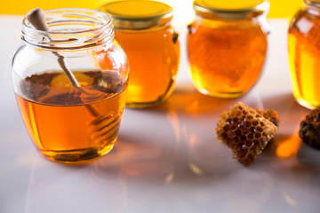 Honey in jar with honey dipper on wooden background
