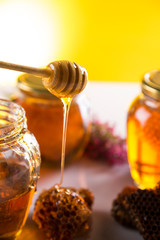 Honey in jar with honey dipper on wooden background