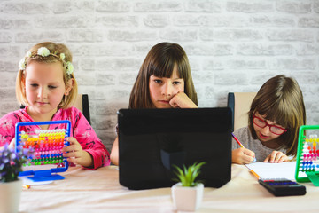 Education, elementary school, learning, technology and people concept. Schoolgirl Watching  Educational Video on laptop Computer Together Inside the room.