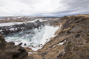 Fototapeta na wymiar Amazing Icelandic winter landscape of majestic waterfall of frozen Gullfoss