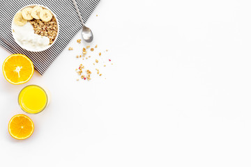 granola with banana slices and orange juice for breakfast on blue background top view copyspace