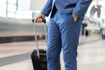 Fototapeta na wymiar Detail of a businessman pulling a trolley in an airport