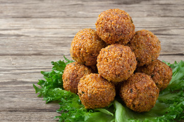 Vegetarian dish - falafel balls from spiced chickpeas on wooden rustic table.