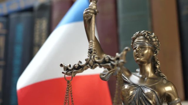 Statue of Lady Justice with Bookshelf with Books and United Kingdom Flag Background. Tribunal and justice concept. Consultation with insurance lawyer and customer