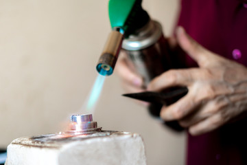 hands of a worker use gas burner in a workshop v