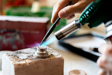 close up photo of factory worker melting maetal with gas burner b
