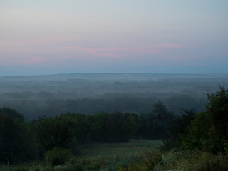 Obraz premium Photo fog over the forest in theearly morning.Beautiful place in nature, ecologically clean area. Traveling and Hiking, camping with the whole family. A great place for meditation, yoga and relaxation