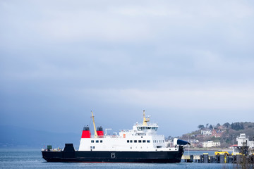 Fototapeta na wymiar Ship ferry at sea under dark blue storm sky in bad weather