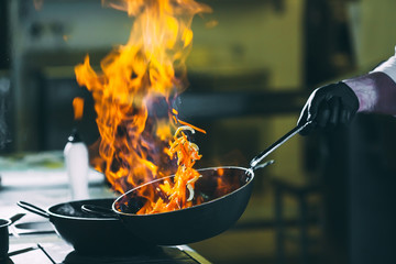Chef is stirring vegetables in wok.