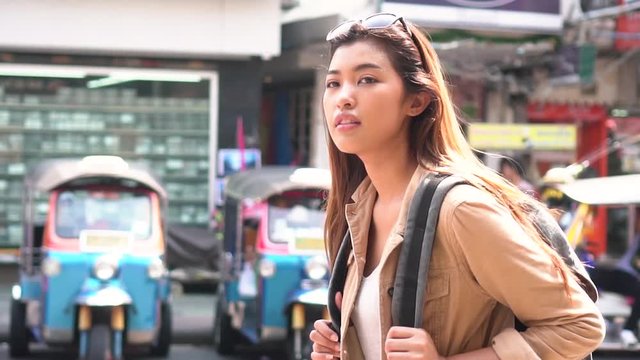 Young Asian female tourist woman with smile walking and backpacking on Khaosan road in Bangkok, Thailand. Travel and Backpack in Asia concept