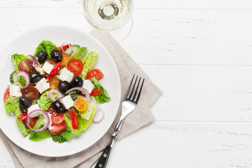 Greek salad plate and white wine