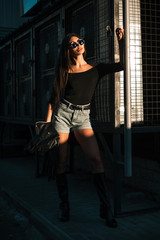 Pretty young sexy fashion model posing on  the street.