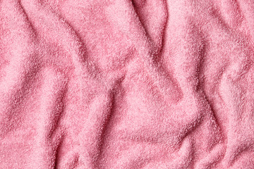Fototapeta na wymiar Soft terry pink towel as background, top view