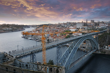Cityscape Panorama of the historic city of Porto, the Don Luis Bridge and the Douro River in Portugal at evening sunset