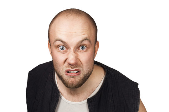 Portrait of angry bald man aggressive thug threatens. Concept portrait of a dangerous criminal on an isolated white background