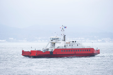 Red ship ferry transport over sea with vehicles onboard