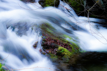 Strumień wody obijający sie o kamień © andsko