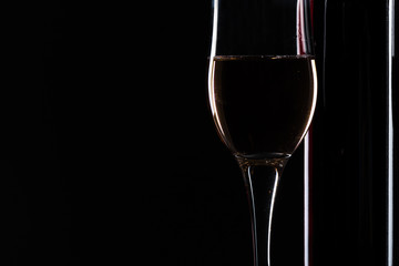  wine bottle and wine glass in a black background