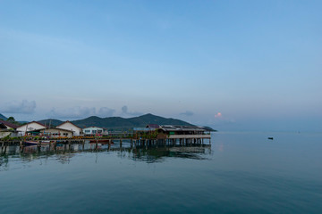 Fisherman's house and seaside house in Sattahip, reflecting with the water surface. Bright sky