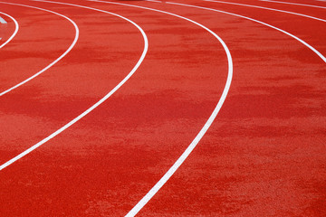 Red artificial running track with white round dividing lines, treadmill rubber texture