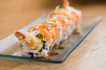 special rice roll with shrimp tempura, avocado, salad, red onion,.cooked salmon, caviar, sliced onion and Teriyaki sauce