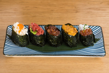 different varieties of gunkan wrapped in nori seaweed, bluefin tuna tartare, caviar of different sizes and colours avocado, sea urchin and squid