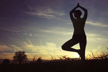 Silhouette of a young girl yoga pose sunset sport