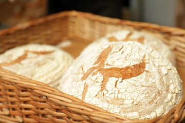 Wicker tray with fresh loaves of bread in bakery