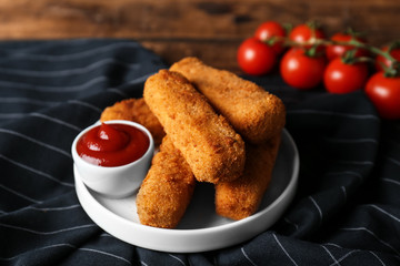 Plate of cheese sticks and sauce on table, closeup