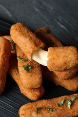 Pile of tasty cheese sticks on table, closeup