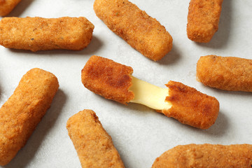 Tasty cheese sticks on grey background, closeup
