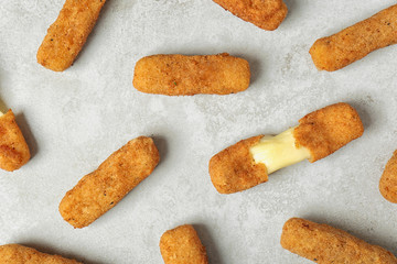 Tasty cheese sticks on grey background, top view