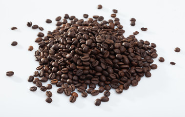 Pile of coffee beans on white surface
