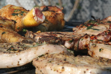 Gewürztes Grillgut, Steak, Kotletts, Hühnerkeulen auf Griller