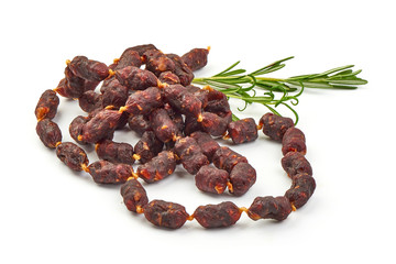 Dry sausages from game with rosemary, close-up, isolated on white background