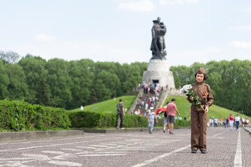 Portrait of a boy with flowers, in the uniform of a soldier of the Red Army during the Second World War. Soviet War Memorial (Treptower Park), Berlin, Germany.
