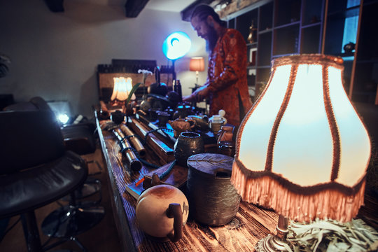 Caucasian master in kimono making natural tea in the dark room with a wooden interior. Tradition, health, harmony. Chinese tea ceremony