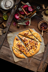 Overhead shot of baked homemade focaccia or pizza with caramelized onion