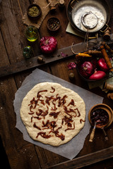 Overhead shot of homemade unbaked focaccia or pizza with caramelized onion